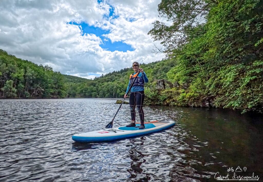 Laurène debout sur un stand up paddle au Lac de Nisramont